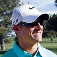 man wearing a hat smiling wearing popticals sunglasses